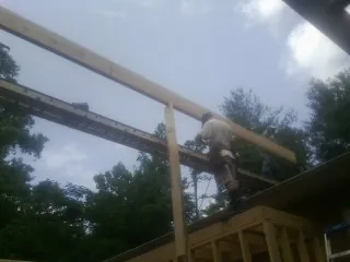Carpenter setting a ridge beam over a new addition frame — Ice Dam Removal by Roofing Brothers in Lititz