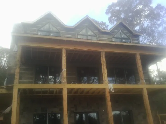 Dormers and porch framing on a large log home under construction — Roof Coating work by our crew in Lititz