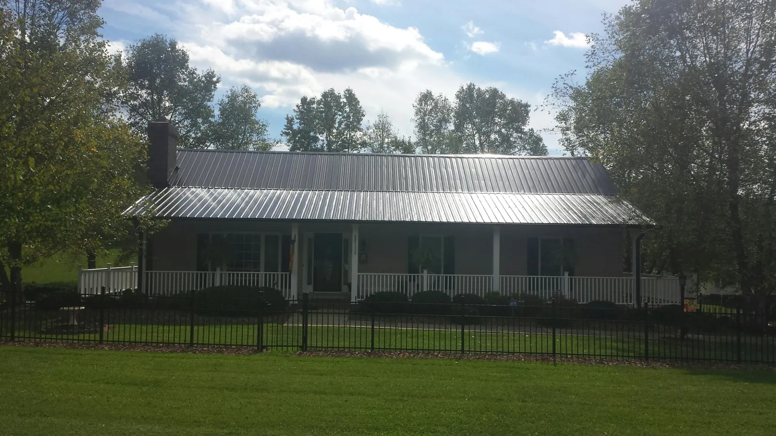 Gray metal roof on a brick ranch with a full width front porch — Gutter Guard Installation work by our crew in Lititz