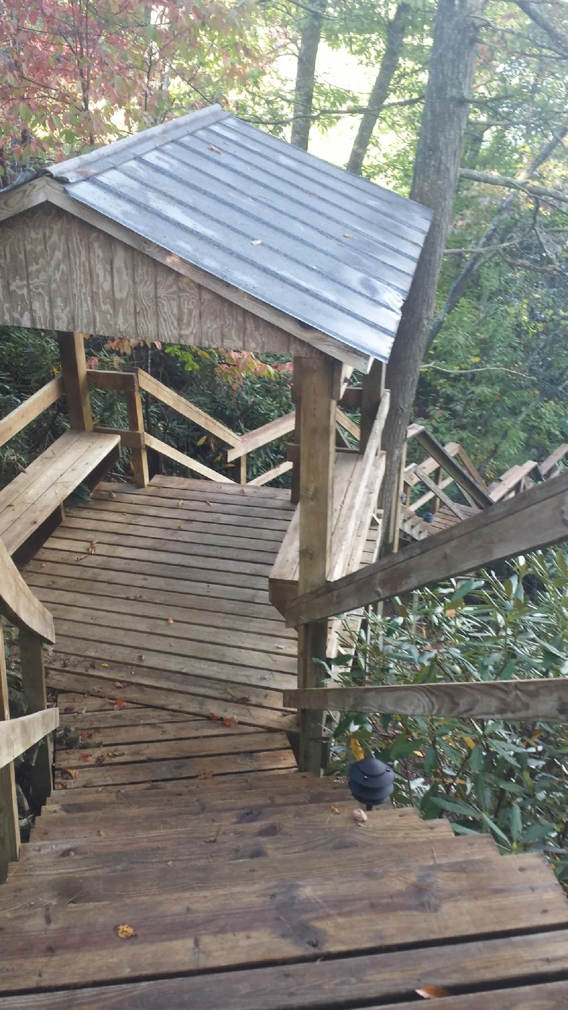 Metal roofed shelter over wooden steps on a wooded walkway — Skylight Repair & Installation work by our crew in Lititz